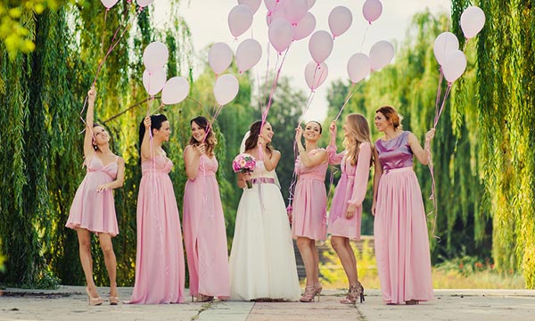 Photo of bride and bridesmaids holding colorful balloons