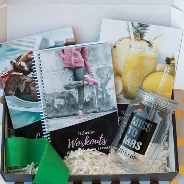 Fitbride box open showing workout book, cookbook, detox guide, mason jar and resistance band