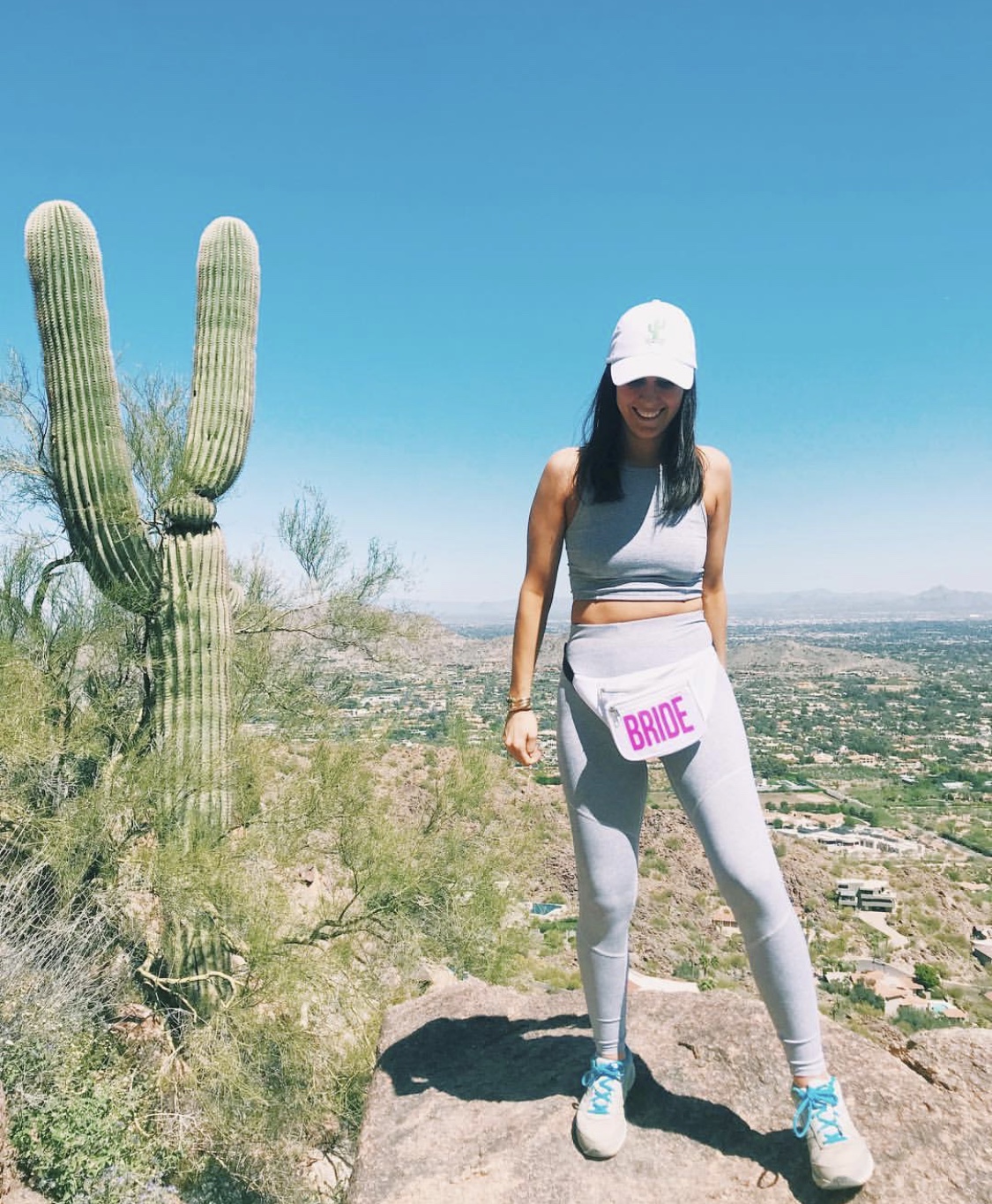 Photo of woman standing on hill wearing a hat