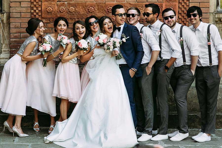 Photo of bridal party in front of brick wall