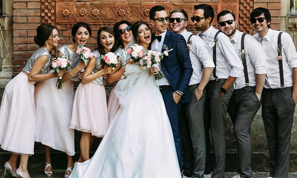 Photo of Bridal Party standing in front of brick wall